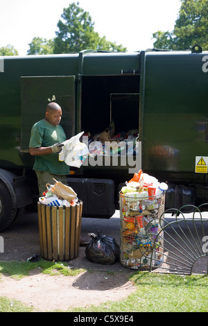 Dustman, lo svuotamento di bidoni in un parco di Londra, pause per la lettura di una mappa che ha trovato nella spazzatura Foto Stock