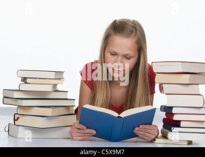 Lettura della ragazza prenota oltre alla pila di libri contro uno sfondo bianco Foto Stock