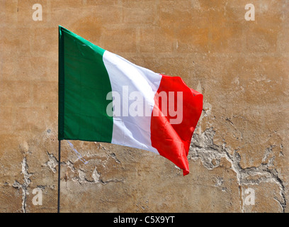 La bandiera italiana, muro di pietra sullo sfondo Foto Stock
