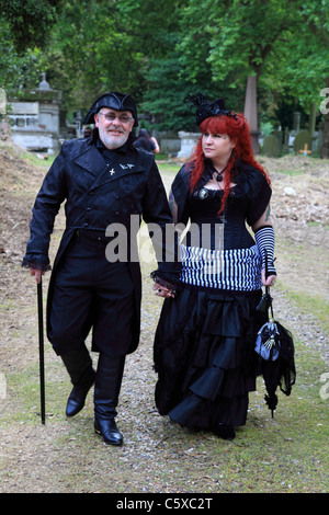 Giovane vestito in abiti in stile vittoriano a piedi a Kensal Green cimitero aperto durante il giorno a Londra, Inghilterra Foto Stock