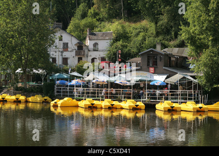 Barche a pedali sono ormeggiate vicino un ristorante dal fiume, la valle dell'Orne, Clécy (Calvados, Swiss Normandia, Francia). Foto Stock