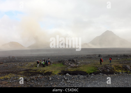 Gli escursionisti in Emstrur Area del Laugavegur (Laugavegurinn) Sentiero Escursionistico con polvere vulcanica Storm dietro, Islanda Foto Stock