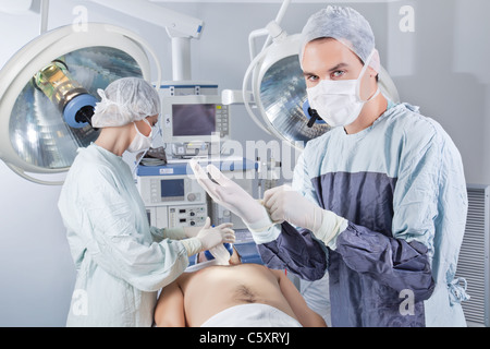 Medico prepararsi prima dell'operazione in sala operatoria Foto Stock