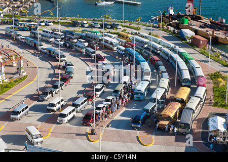 La nave di crociera i passeggeri a piedi in attesa di furgoni e autobus per escursioni sull'Isola di Roatan in Honduras Foto Stock