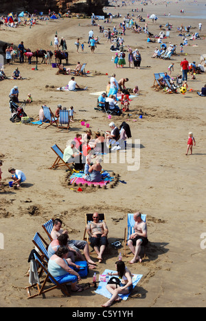 La folla di gente sulla spiaggia in riva al mare. Foto Stock