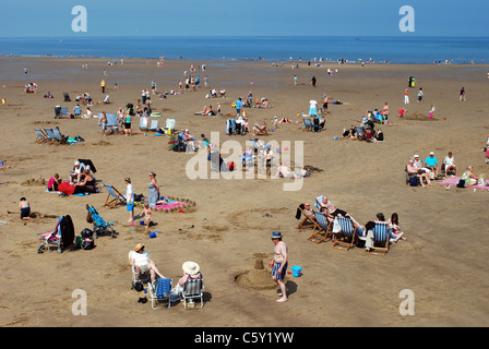 La folla di gente sulla spiaggia in riva al mare. Foto Stock