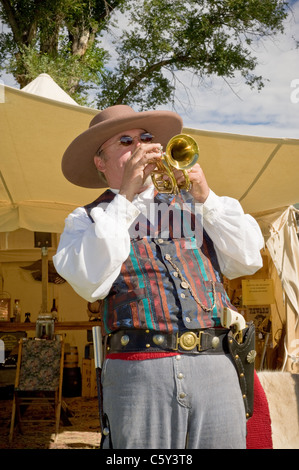 Un uomo in un colorato costume pioneer svolge un vivace tromba tune a Fort Stanton Live, Fort Stanton, Lincoln County, Nuovo Messico. Foto Stock