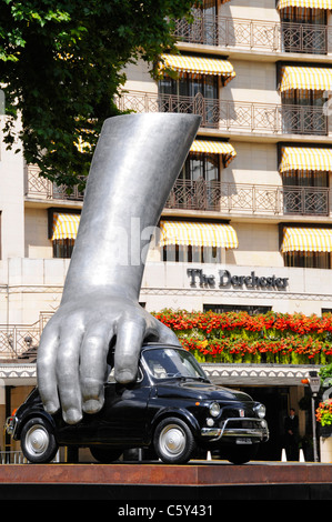 Mano sul Vintage Fiat Auto in arte moderna scultura "Vroom Vroom" dell'artista italiano Lorenzo Quinn fuori Dorchester Hotel di Mayfair London REGNO UNITO Foto Stock
