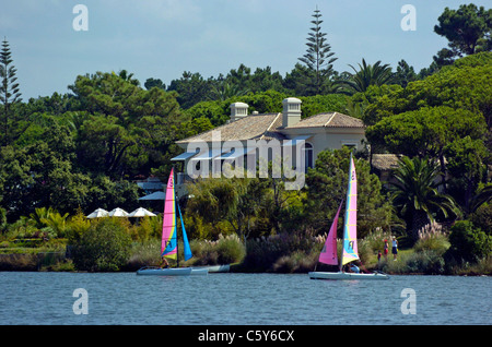 In barca a vela nella parte anteriore del case in riva al lago nella sistemazione di area di Quinta do Lago area dell'Algarve, Portogallo. Foto Stock