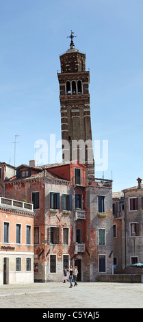 Uno dei molti pendente torri della chiesa a Venezia, Italia con antico edificio di fronte mostra di architettura. Foto Stock