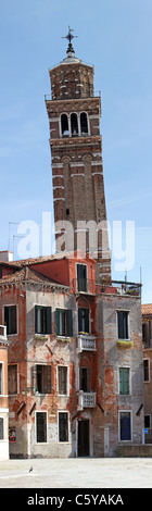 Uno dei molti pendente torri della chiesa a Venezia, Italia con antico edificio di fronte mostra di architettura. Foto Stock