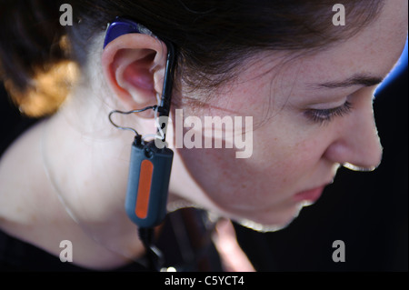 Femmina e giovane studente per audiologia indossando un apparecchio auditivo apparecchiatura per una prova nel suo orecchio destro Foto Stock