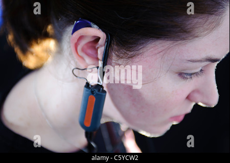 Femmina e giovane studente per audiologia indossando un apparecchio auditivo apparecchiatura per una prova nel suo orecchio destro Foto Stock