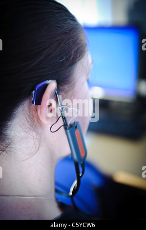 Femmina e giovane studente per audiologia indossando un apparecchio auditivo apparecchiatura per una prova nel suo orecchio destro Foto Stock