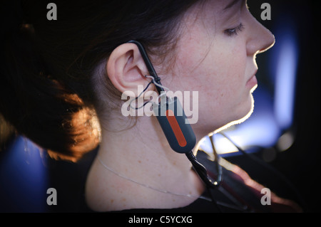 Femmina e giovane studente per audiologia indossando un apparecchio auditivo apparecchiatura per una prova nel suo orecchio destro Foto Stock