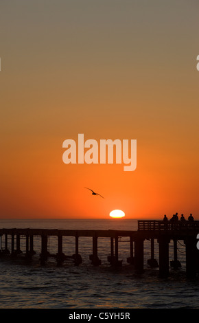 In inverno il sole tramonta sul molo e il sud dell'Oceano Atlantico. Swakopmund, Namibia. Foto Stock