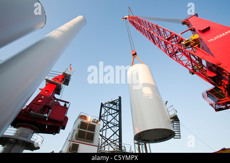 Un jack up barge abbassamento di una torre a turbina eolica il pezzo in posizione sulla Walney offshore wind farm. Foto Stock