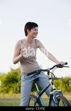 Russia, Voronezh, donna in bici acqua potabile Foto Stock