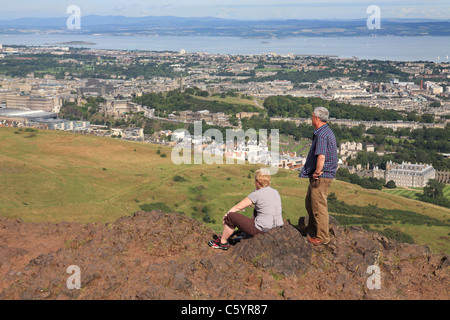 Una coppia matura guardando il nostro da Arthur' Seat, Edimburgo, Scozia, Regno Unito Foto Stock