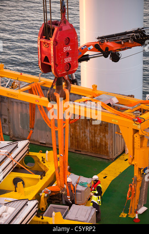 Preparare i lavoratori per il sollevamento di una turbina eolica ogiva sul jack up barge, Kraken, caricato con turbine eoliche per l'Offshore Walney Foto Stock