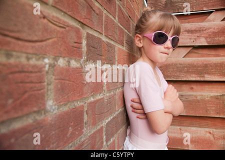 Una giovane ragazza la visualizzazione di atteggiamento e di broncio nell'angolo Foto Stock