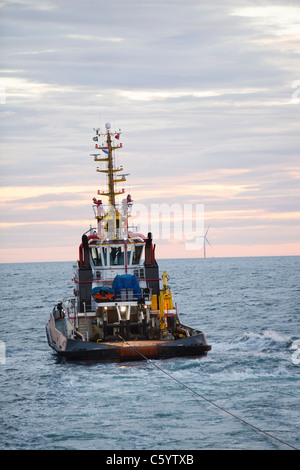 Un rimorchiatore traina il jack up barge il Goliath verso il Walney per centrali eoliche offshore project, off Barrow in Furness, Cumbria, Regno Unito, Foto Stock