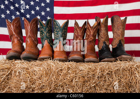 Stati Uniti d'America, Illinois, Metamora, Fila di stivali da cowboy il pagliaio con bandiera americana sullo sfondo Foto Stock