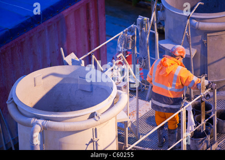 Specialista di miscelazione boiacca per fissare pezzi di turbine eoliche in posizione sul Walney offshore wind farm, UK. Foto Stock