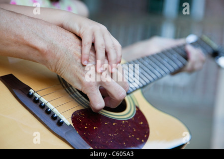 Stati Uniti d'America, Illinois, Metamora, Nonna e nipote (4-5) mani a suonare la chitarra Foto Stock