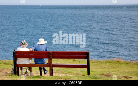 Un vecchio paio di sedersi su una scogliera sede sulla costa sud dell'Inghilterra che si affaccia sul canale in lingua inglese Foto Stock