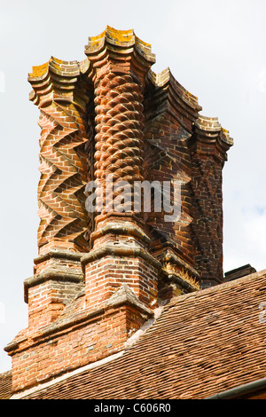 Comignoli decorativi costruito da scolpita in mattoni in stile giacobino su un edificio in inglese Foto Stock