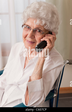 Stati Uniti d'America, Illinois, Metamora, Ritratto di sorridere senior donna su una sedia a rotelle parlando al telefono Foto Stock