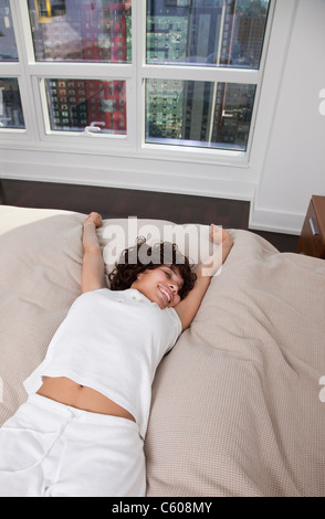 Stati Uniti d'America, New York City, donna stretching sul letto Foto Stock