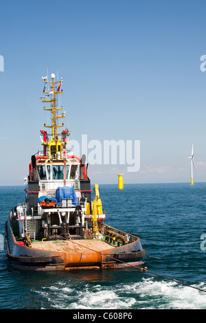 Un rimorchiatore che traina un jack up barge in posizione per costruire il Walney offshore wind farm, Cumbria, Regno Unito. Foto Stock