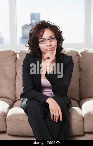 Stati Uniti d'America, nello Stato di New York, New York City, ritratto di donna seduta su un divano Foto Stock
