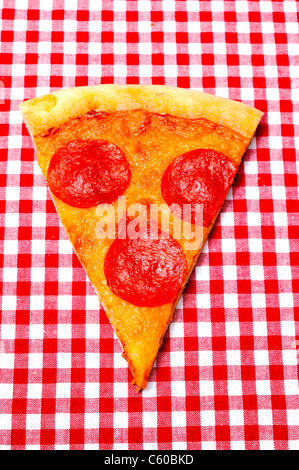 Salsiccia per Pizza Pizza Slice su rosso Gingham Closeup Foto Stock