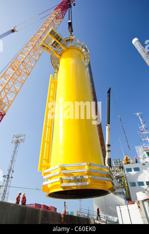 Una gru solleva un pezzo di transizione di una turbina eolica su un martinetto fino barge, pronti a costruire il Walney offshore wind farm Foto Stock