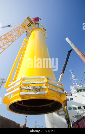 Una gru solleva un pezzo di transizione di una turbina eolica su un martinetto fino barge, pronti a costruire il Walney offshore wind farm Foto Stock