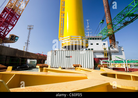 Una gru solleva un pezzo di transizione di una turbina eolica su un martinetto fino barge, pronti a costruire il Walney offshore wind farm Foto Stock