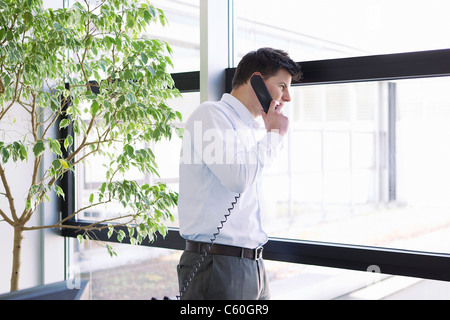 Imprenditore parlando al telefono in ufficio Foto Stock