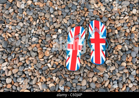 Unione jack flip flop sulla spiaggia ghiaiosa Foto Stock