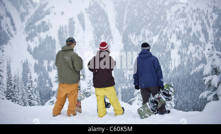 Gli appassionati di snowboard ammirando montagna Foto Stock