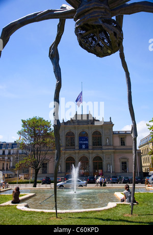 'Maman' spider scultura su display a Place de Neuve a Ginevra con il Conservatoire de musique de Genève visto attraverso di esso Foto Stock