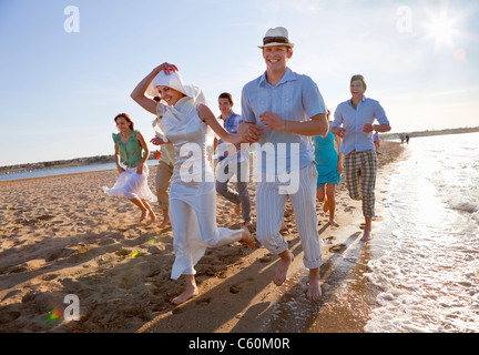 Sposa giovane sulla spiaggia con gli amici Foto Stock