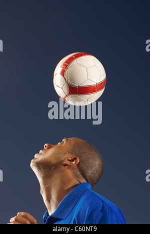 L'uomo bouncing soccer ball sulla sua testa Foto Stock