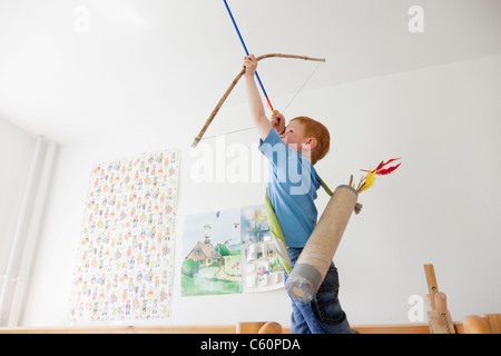 Ragazzo giocando con toy arco e frecce Foto Stock