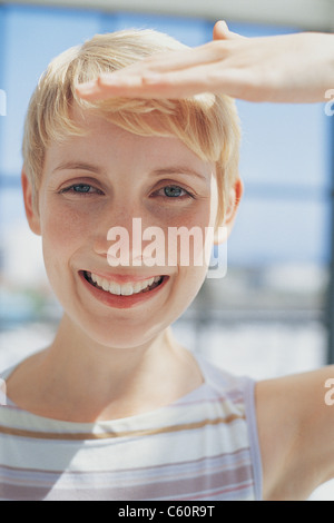La donna gli occhi di schermatura da parte di Sun Foto Stock