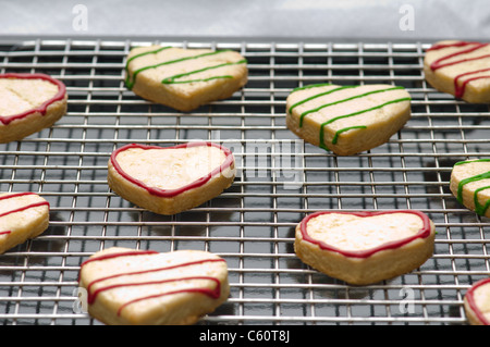 Decorate forma di cuore biscotti di Natale sul vassoio di supporto Foto Stock