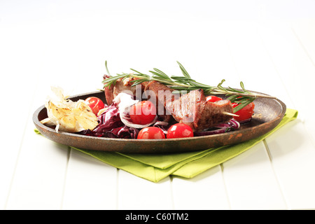 Shish kebab con aglio arrostito e pomodorini Foto Stock