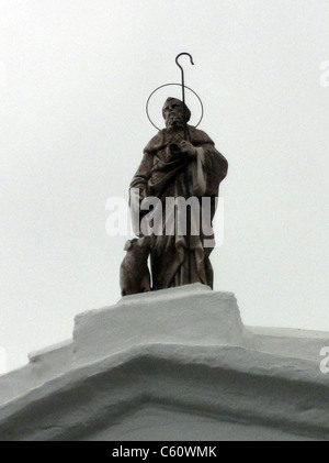 Una figura religiosa sulla parte superiore di una chiesa Foto Stock